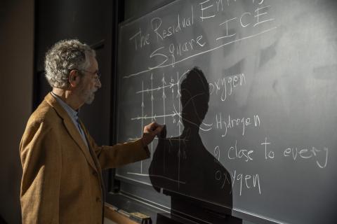 Dr Elliott Lieb writing on a chalk board